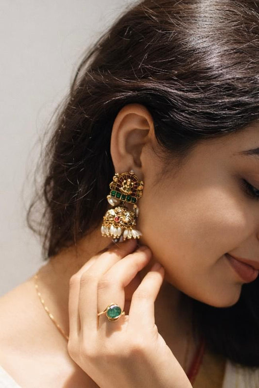 Elegant South Indian temple earrings with emerald and pearl accents, paired with a matching ring.