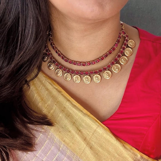 Elegant South Indian temple necklace with red kemp stones and gold coin motifs, paired with a silk saree.