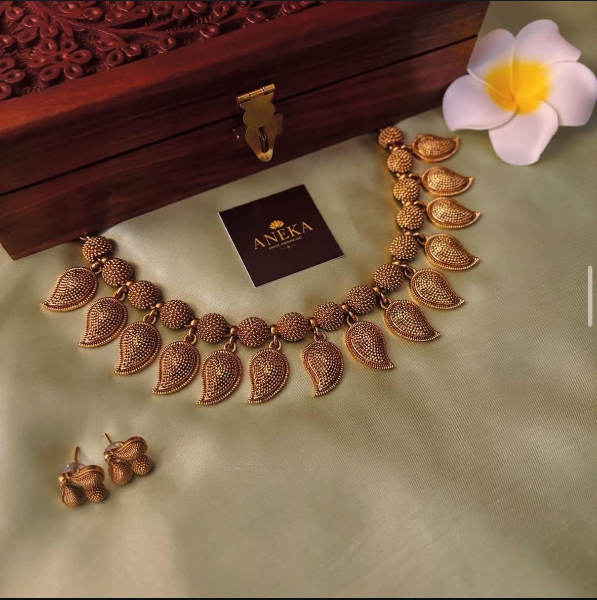 Elegant South Indian temple jewellery set with intricate gold leaf motifs and matching earrings